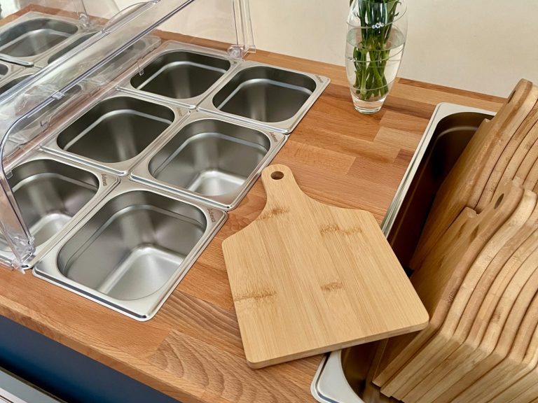 Le Petit Chariot luxury grazing cart ready for dry hire at weddings, parties or corporate evetns Individual wooden serving board next to stainless steel food storage containers on the Le Petit Chariot luxury grazing cart.