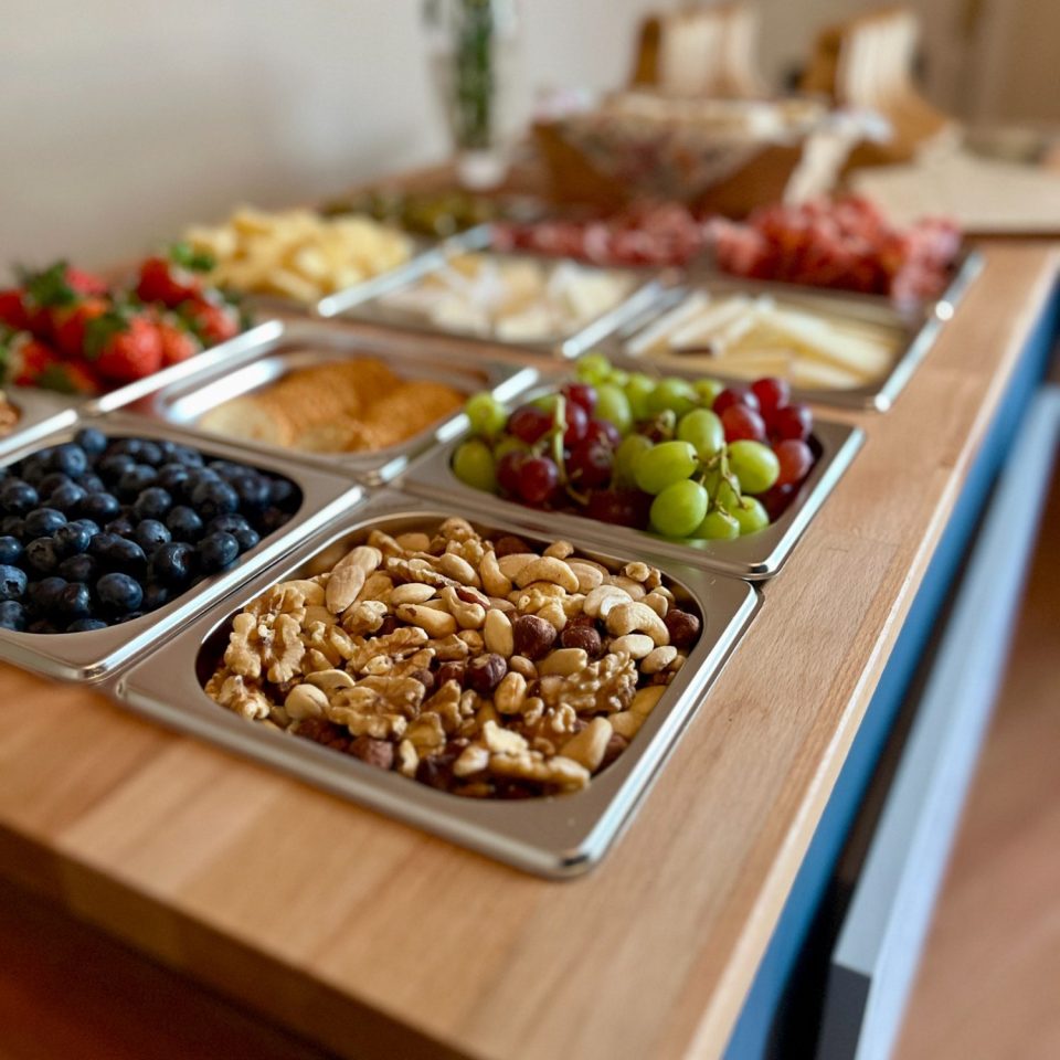 A selection of fruits, nuts, cheeses, and charcuterie meats arranged on the Le Petit Chariot luxury grazing cart, ready for a wedding.